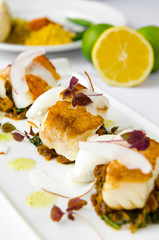 Fresh pan seared, crispy golden cod fish fillet, served on a bed of curried cauliflower, spinach and potato. A beautiful seafood dish.
