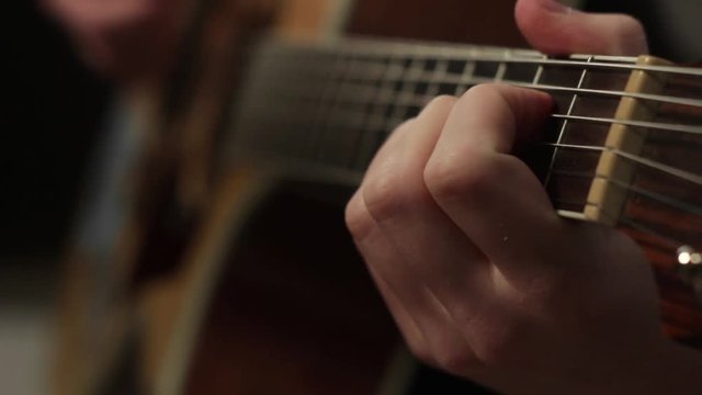 playing on the acoustic guitar. Musical instrument with guitarist hands