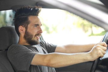 Portrait of handsome young man driving car