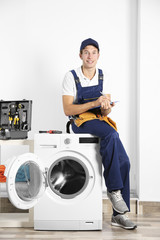 Obraz premium Hydraulik siedzi na pralce