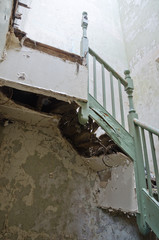 An old rotten broken wooden staircase that has been left to rot in an abandoned building. Stairs are un safe and are a health and safety risk.