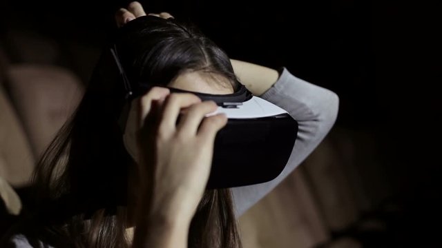 The girl puts on glasses and gets into virtual reality. Virtual reality mask. 