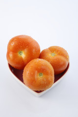 fresh red delicious tomatoes in heart-shape plate