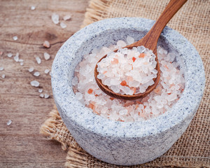 Himalayan pink salt in mortar on hemp sack background. Himalayan