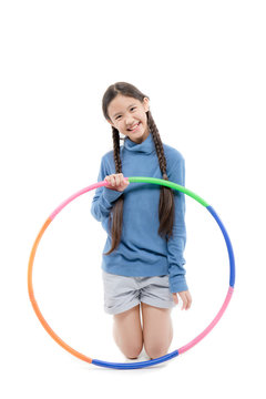 Portrait of happy little Asian child girl playing hulahoop on isolated white background