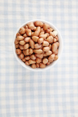 top view of the ground nut in the round shape container on top  checker mat