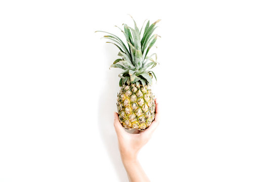 girl's hand holding pineapple. flat lat, top view