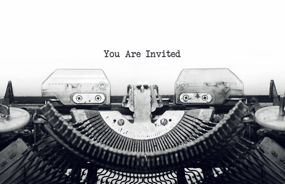 Vintage typewriter on white background with text you are invited