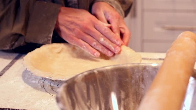 Woman pressing pie dough close up on hands- slider shot