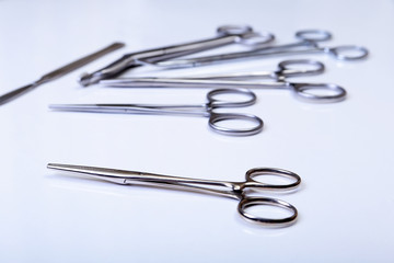 surgical instruments and tools including scalpels, forceps tweezers arranged on a table for surgery