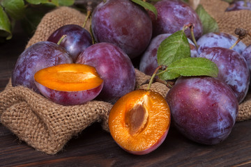 Fototapeta premium plums on the wooden background with sackcloth