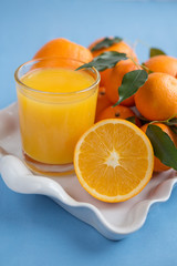 Juice and oranges on a tray on a blue background