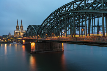 Fototapeta premium Bridge over the Rhine river in Cologne at the early morning blue hours sun light