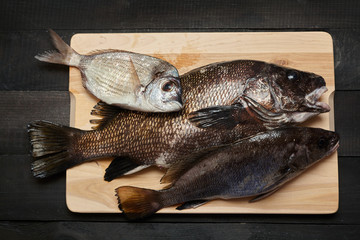 Raw fish on wooden cutting board