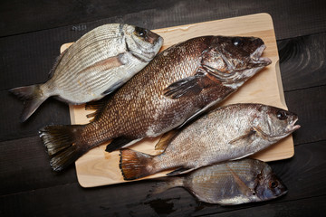 Raw fish on wooden cutting board