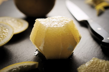 Peeled organic bittersweet grapefruit with zest on dark backgrou