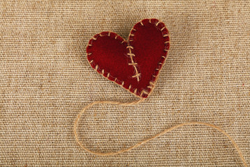 Brown felt craft heart over canvas close up