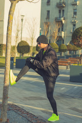 Urban jogger stretching in the park.