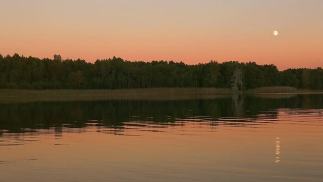 Full moon reflecting in a lake.