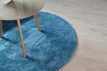 close up of blue carpet on wood floor with table