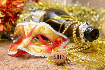 An open bottle of champagne on a Golden background and the inscription 2017 on the tube. New year's holiday.