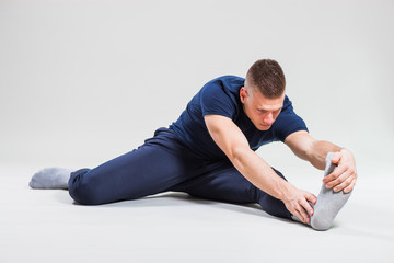 Fototapeta premium Studio shot image of young man who is stretching his body. 