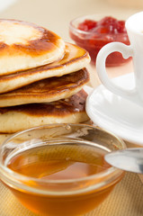 Pancake with honey and jam and white cup of tea