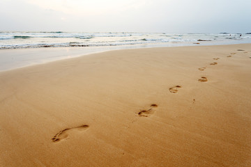 Footsteps on the evening beach, background