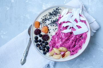 Breakfast purple berry smoothie bowl on a concrete background. Love for a healthy raw food concept.