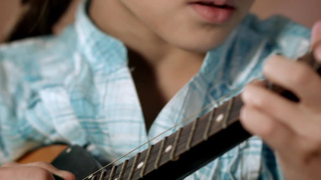Close-up girls hand. Girl learning to play mandolin