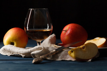 Apple cider in wine glass with cinnamon sticks and fresh apples