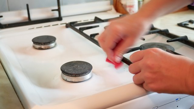 Woman Washes A Gas Stove In Cleaning The Kitchen