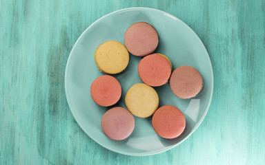 Photo of macarons on teal blue plate with copyspace