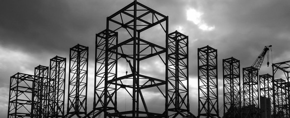 Silhouette shot of mega steel structure with crane in background. Shoot in black and white shot with dramatic sunset light.
