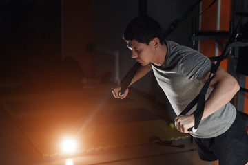 Attractive Man Does Crossfit Push Ups With Trx Fitness Straps In The Gym's Studio.