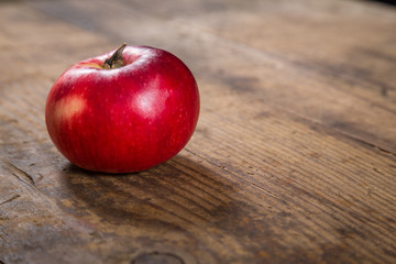 red apple on dark wooden table