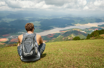 Naklejka na ściany i meble Traveller gray backpack resting enjoying the sunny valley of mou