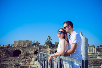 Fototapeta na wymiar Happy romantic couple embracing each other against the background of the ruins of the ancient city