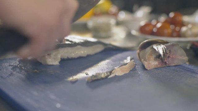 Kitchen knife cutting raw fish, slow motion