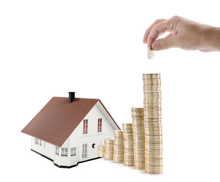 Male hand puts another Euro on savings for house investment isolated on white background.