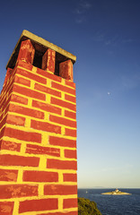 Bunter Schornstein an der Küste mit Blick aufs Meer