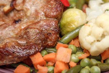 Grilled steak with vegetables and herbs on plate