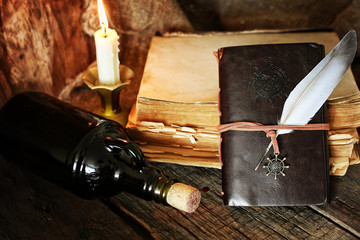diary and feather with a bottle of rum