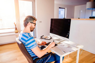 Man sitting at desk working from home on computer