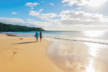 Young couple walking on the beach at sunset