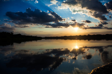 Reflection of the sun at sunset in the Limoncocha lagoon in the Ecuadorian Amazon