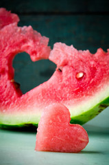 Fresh juicy watermelon heart at turquoise wooden background. Saint Valentine, love greeting card
