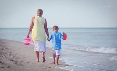 Grandmother and grandson walking at tropical beach