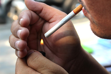 young man lighting cigarette