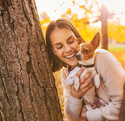 Portrait of young happy woman holding little cute dog